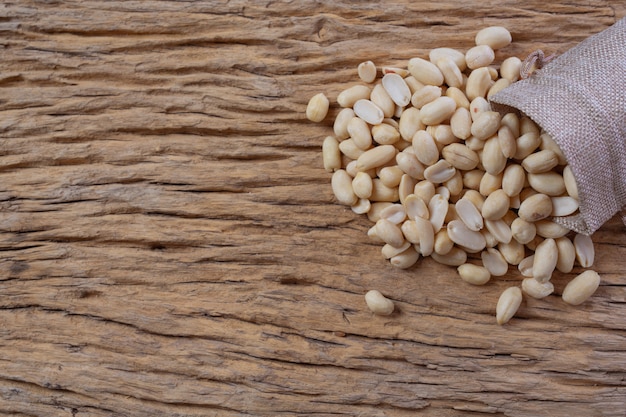 Peanut seeds on a wooden background in the kitchen