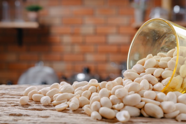 Peanut seeds on a wooden background in the kitchen