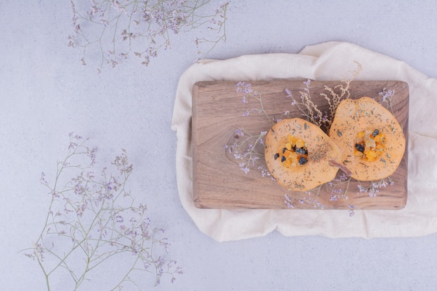 Pear slices with herbs and spices on a wooden board