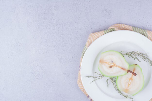 Pear slices with herbs in a white plate