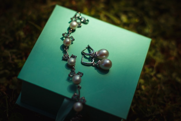 Free photo pearl jewerly lies on mint box