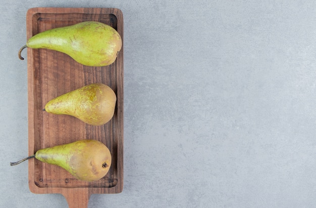 Pears arranged on a small tray on marble 