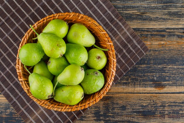 Pears in a basket flat lay on wooden and placemat background