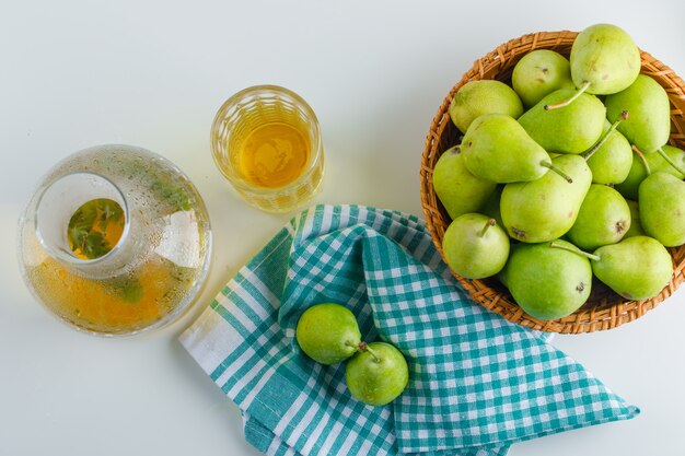 Pears in a basket with drink top view on white and kitchen towel