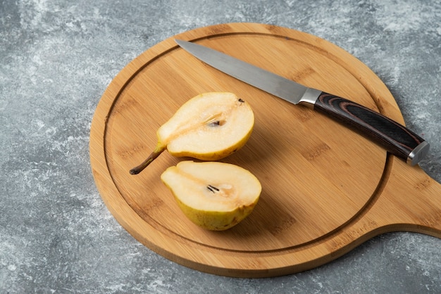 Pears cut into half on a wooden platter. 