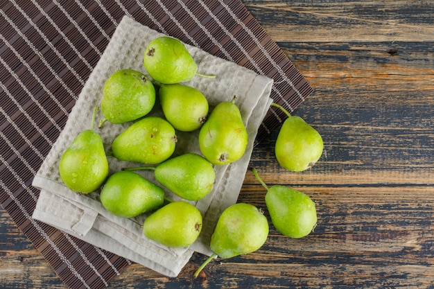 Pears on a kitchen towel flat lay on wooden and placemat background
