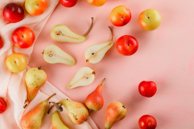 Pears and plums on pink and textile surfacae