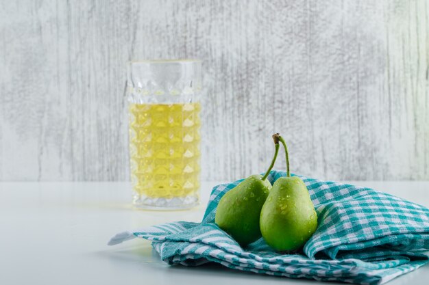 Pears with drink, kitchen towel on white and grungy wall