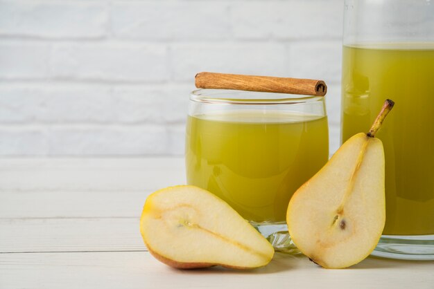 Pears with a glass jar of juice and cinnamon sticks