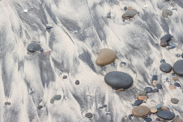 Pebble on sandy beach and stones