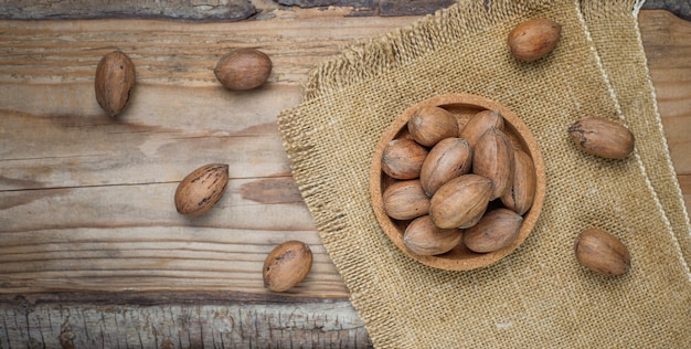 Pecan nuts on rustic, top view