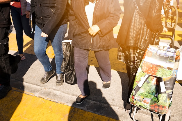 Pedoni che attraversano la strada con le borse