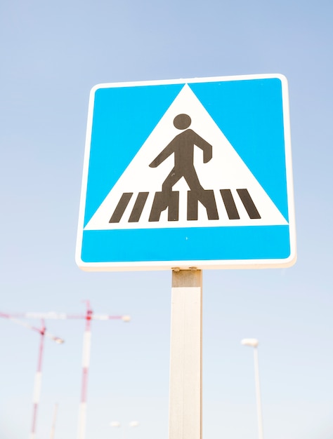 Pedestrians warning sign against blue sky