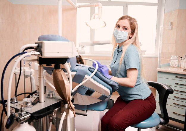 Pediatric dentist checking child teeth in dental office