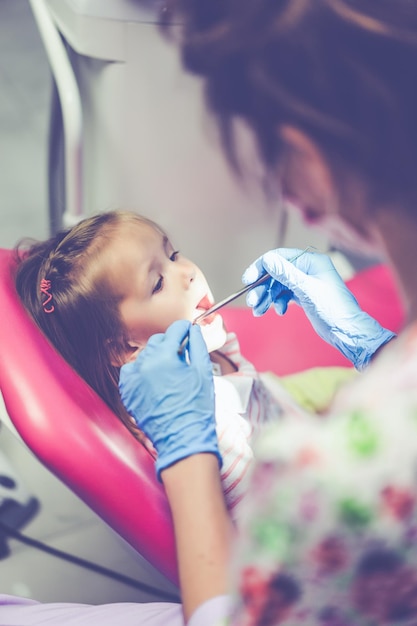 Free photo pediatric dentist. little girl at the reception at the dentist.