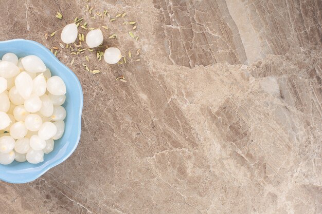 Spicchi d'aglio sbucciati posti su un tavolo di pietra.