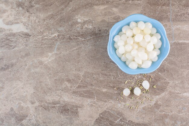 Peeled cloves of garlic placed on a stone table.