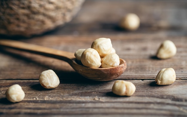 Free photo peeled hazelnuts in a wooden spoon closeup