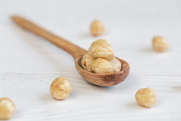 Peeled hazelnuts in a wooden spoon closeup