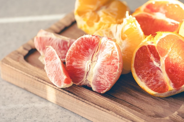 Peeled oranges on a wooden board on the kitchen table