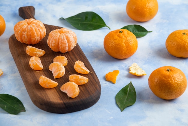 Peeled organic mandarins beside of whole mandarins