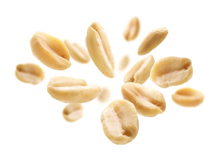 Peeled peanuts levitate on a white background