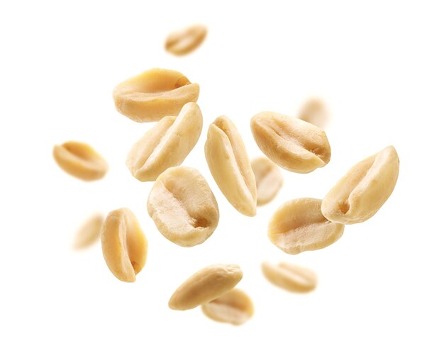 Peeled peanuts levitate on a white background