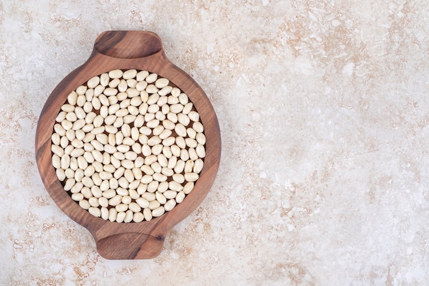 Peeled peanuts on a wooden plate, on the marble.