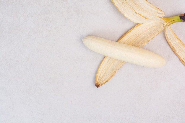 Free photo peeled single banana on white table