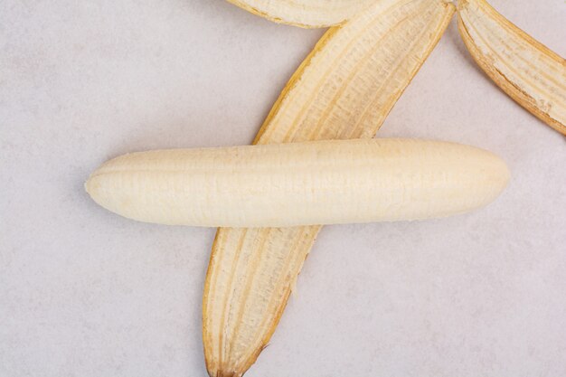 Free photo peeled single banana on white table