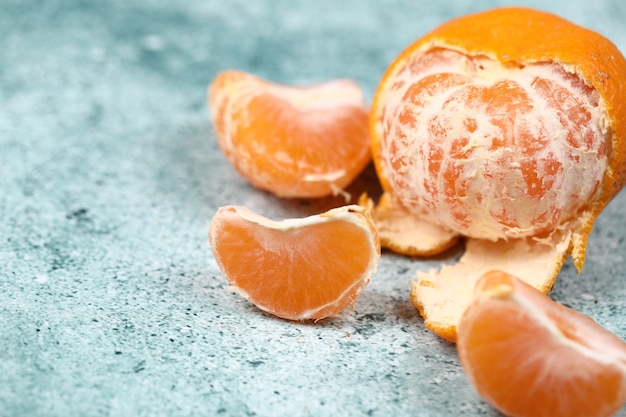 Free photo peeled and sliced mandarin oranges on a blue background.