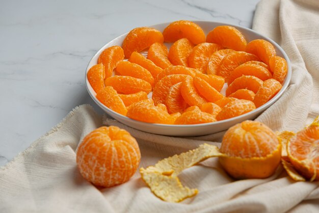 Peeled tangerines on marble background