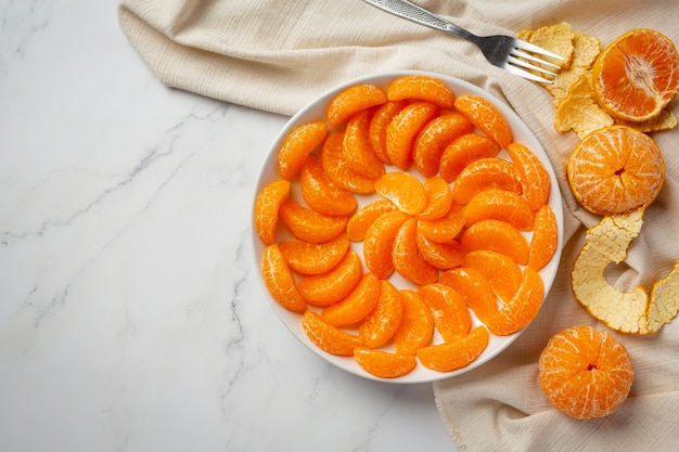 Peeled tangerines on marble background