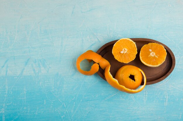 Peeled yellow oranes in a wooden platter