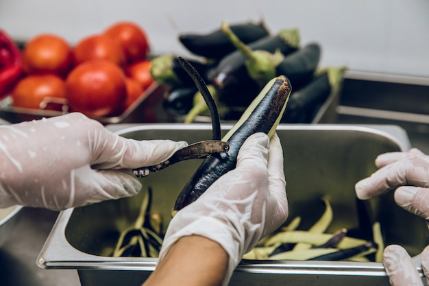 Free photo peeling the black skin of eggplants