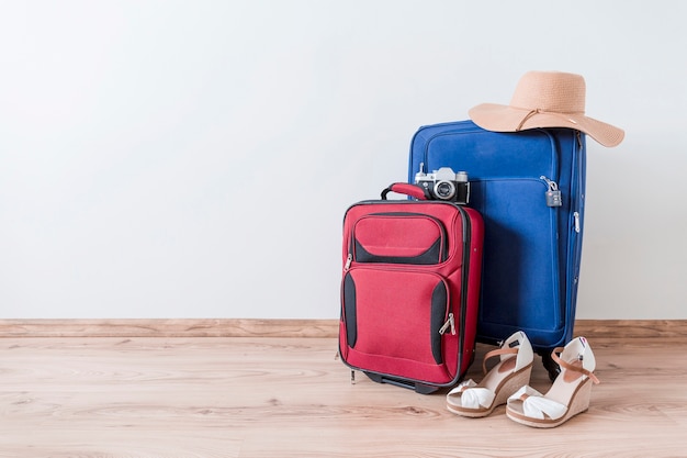 Peep-toe shoes and hat near suitcases and camera