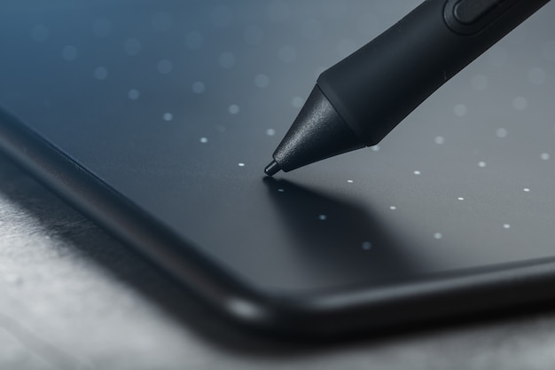 Pen and graphic tablet close-up on a gray textural background. gadget for working as a designer, artist and photographer.