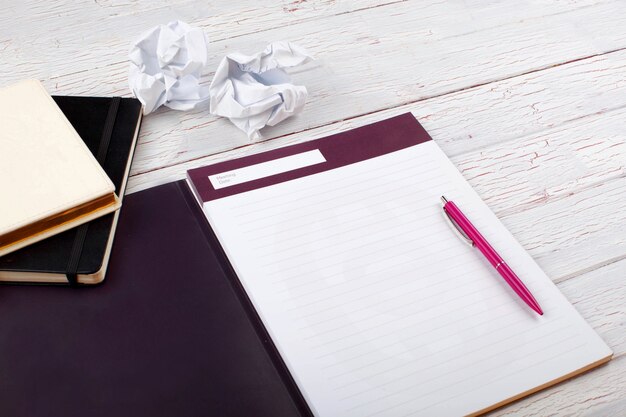 The pen,notebooks and papers stand on the table