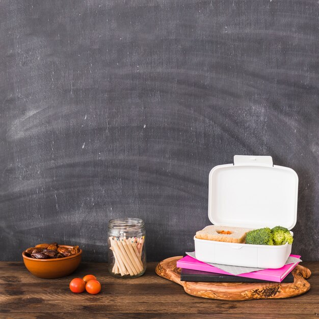 Pencils near healthy food and notebooks