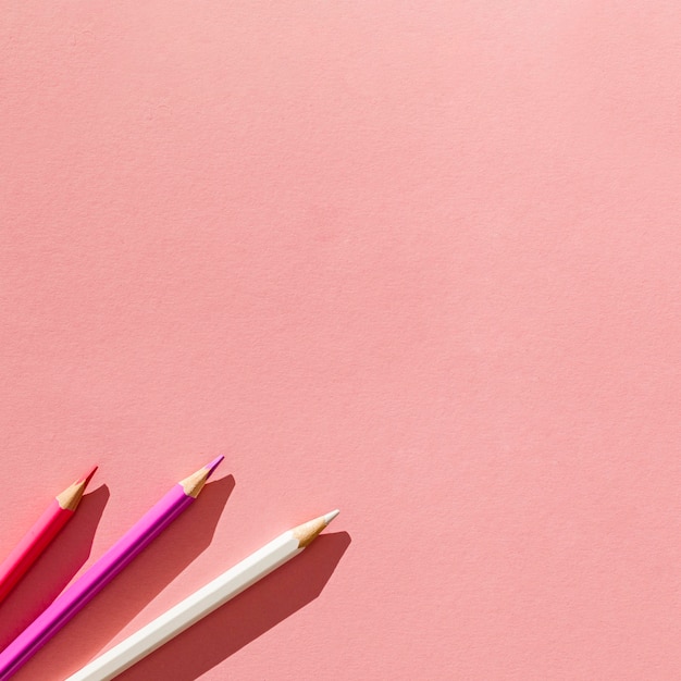 Pencils on pink background arrangement
