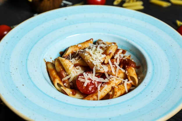 Free photo penne pasta with tomato sauce and parmesan