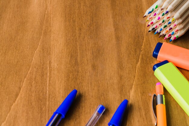 Pens, pencils and markers on wooden desk