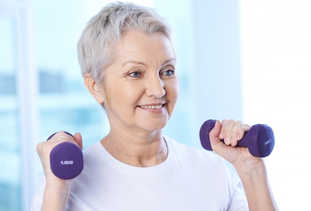 Free photo pensioner with dumbbells