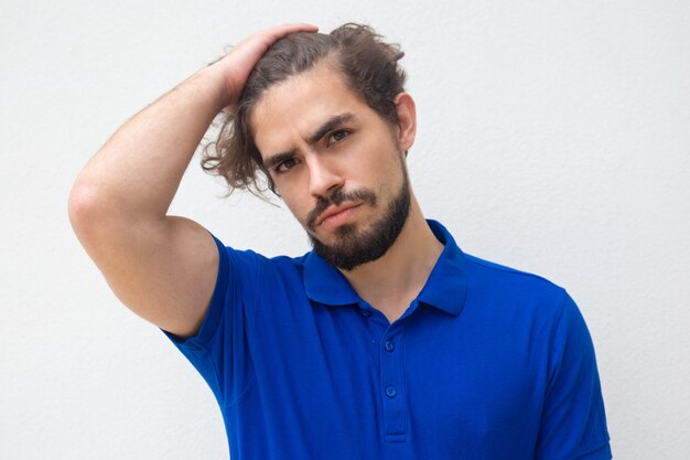 Pensive attractive guy touching head