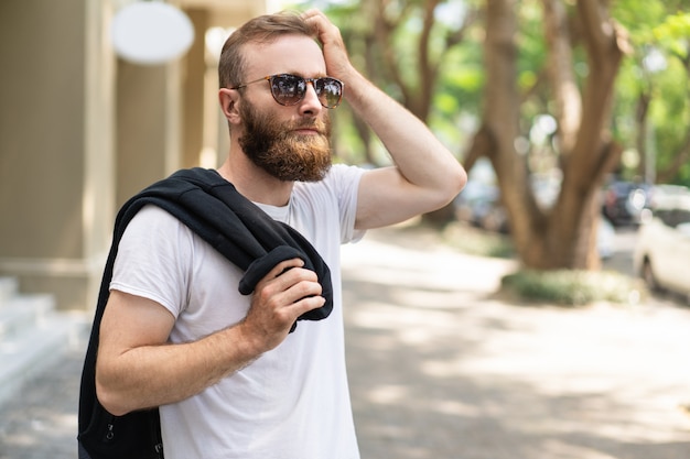 Pensive bearded guy waiting for girlfriend