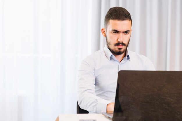 Pensive businessman at laptop