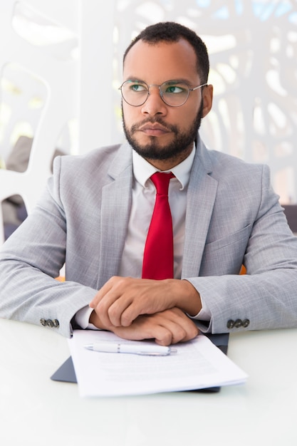 Pensive businessman thinking over agreement