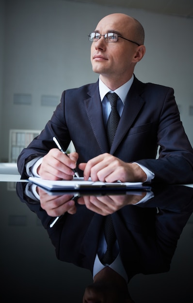 Free photo pensive businessman with clipboard