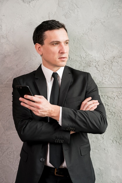 Pensive businessman with crossed arms looking away