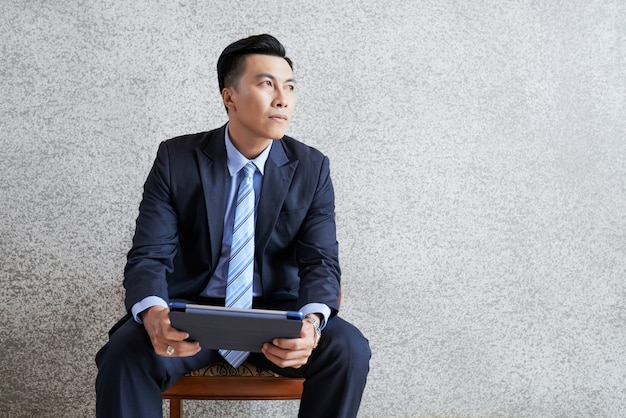 Pensive businessman with tablet